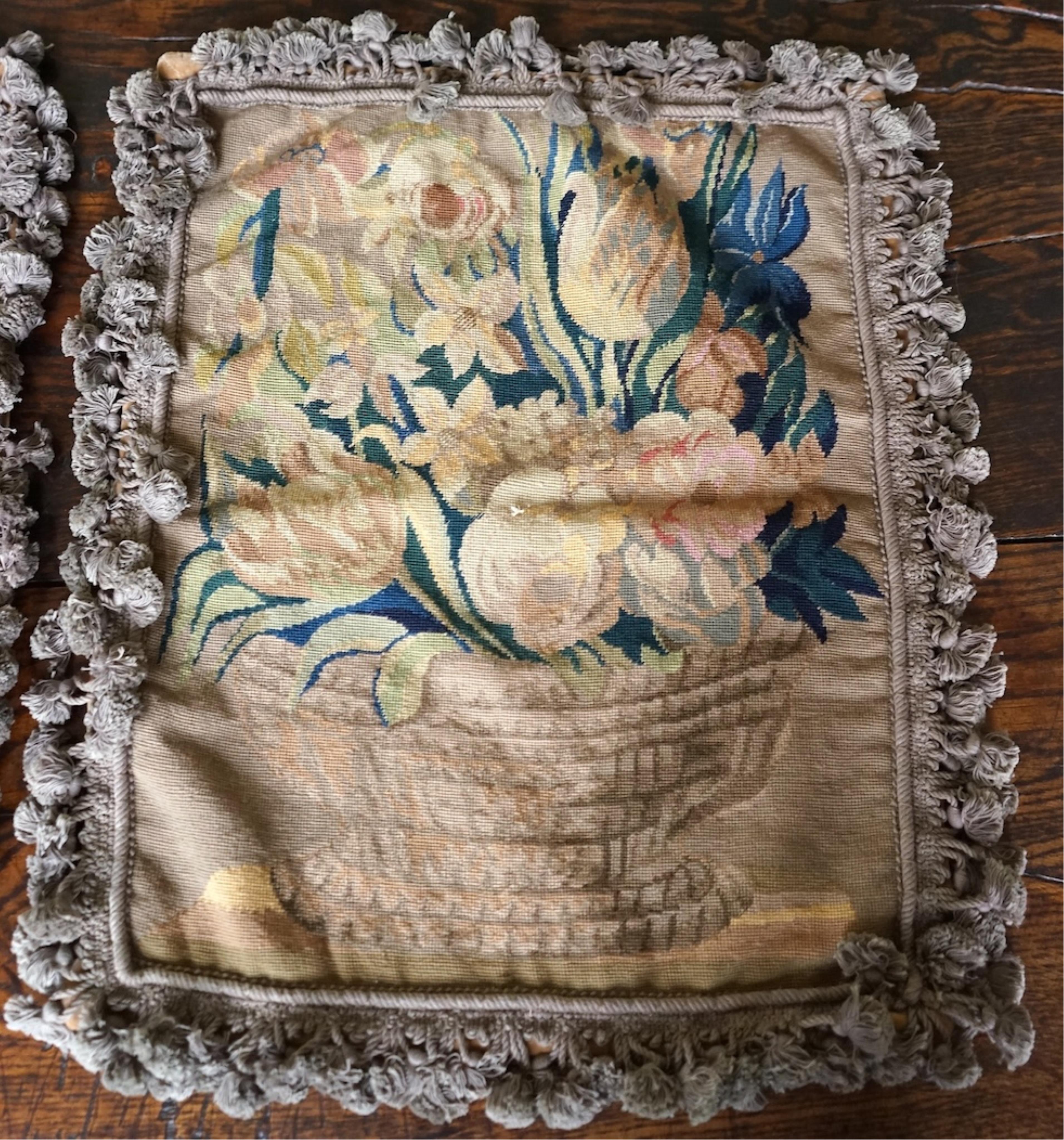 Four large rectangular wool worked cushion covers, with a still life design of a bowl of roses, tulips and daffodils. Embroidered in very muted colours, with ornate tasseled braid and velvet backing. 48cm high x 39cm wid